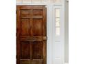 Close-up of a beautiful wooden front door with white trim and sidelight window at 201 River Rd., Georgetown, SC 29440