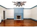 Spacious living room features a blue accent fireplace and lovely hardwood floors at 201 River Rd., Georgetown, SC 29440