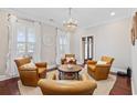 Cozy sitting area with hardwood floors, four leather chairs around a round coffee table, and natural light from the windows at 208 Wahee Pl., Conway, SC 29527
