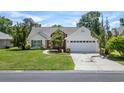 Beautiful home with a two-car garage, lovely landscaping, and a welcoming red front door at 278 Tibton Circle, Myrtle Beach, SC 29588
