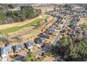An aerial shot shows a home located on a golf course, surrounded by lush trees and other beautiful homes at 387 Foxtail Dr., Longs, SC 29568