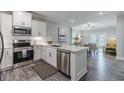 Modern kitchen with white cabinets, stainless steel appliances, and an island with seating at 395 S Crow Creek Dr. # 1710, Calabash, NC 28467