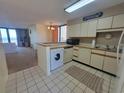 Well-maintained kitchen with white cabinets, washer, dryer, microwave, and tile floors at 4719 S Ocean Blvd. # 209, North Myrtle Beach, SC 29582