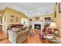 Cozy living room featuring a fireplace, ceiling fan, and hardwood floors at 540 Alderly Ct., Little River, SC 29566