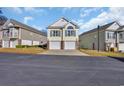 View of the two-story townhome with a dual garage, sidewalks, and manicured landscaping at 670 2Nd Ave. N, North Myrtle Beach, SC 29582