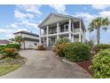 Two-story traditional home boasts grand columns, double balconies, mature landscaping, and a circular driveway at 898 Bluffview Dr., Myrtle Beach, SC 29579