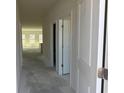 Bright hallway showcasing access to various rooms with natural light and neutral color palette at 1013 Jase Dr., Longs, SC 29568