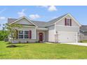 Beautiful one-story home with a two-car garage, lush green lawn, and attractive exterior details at 119 Old Chimney Ln, Conway, SC 29526
