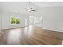 Open-concept living room featuring hardwood floors, a ceiling fan, and abundant natural light at 119 Old Chimney Ln, Conway, SC 29526