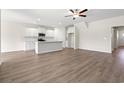 Bright open-concept living room with hardwood floors and white kitchen cabinets at 127 Old Chimney Ln, Conway, SC 29526