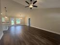Open-concept living room boasts hardwood floors, a vaulted ceiling, and stylish lighting fixtures at 130 Palm Dr., Loris, SC 29569