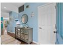 Entryway with mirrored cabinet, shiplap accent, and white front door at 1827 Spinnaker Dr., North Myrtle Beach, SC 29582