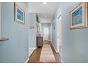 Hallway with blue walls, art, side table with lamp, and neutral rug at 1827 Spinnaker Dr., North Myrtle Beach, SC 29582