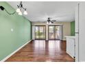 Bright living room features hardwood floors, ceiling fan and sliding glass doors for natural light at 1881 Colony Dr. # 8-P, Surfside Beach, SC 29575