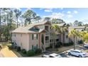 A condominium complex with a neutral exterior, accentuated by green shutters and complemented by a well-maintained lawn at 270 Pinehurst Ln. # 9G, Pawleys Island, SC 29585