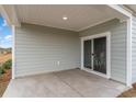 View of the covered patio, showing the flooring, ceiling, and sliding glass door at 4525 East Coast Ln., Shallotte, NC 28470