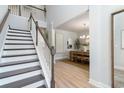 Elegant entryway with staircase and dining room featuring modern chandelier and light wood floors at 534 Haven View Way, Murrells Inlet, SC 29576