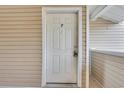 Private entrance door to the condo featuring secure lock and neutral siding at 8735 Chandler Dr. # F, Surfside Beach, SC 29575