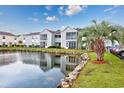 Building exterior with a serene water view, palm tree, and rock-lined landscape at 8861 Cloister Dr. # F, Surfside Beach, SC 29575