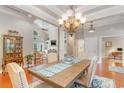 Open-concept dining room featuring a stylish chandelier, tray ceiling, and views of the living area at 921 Heshbon Dr., North Myrtle Beach, SC 29582