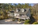 Inviting two-story beach house with a charming facade, dormer windows, and a wraparound porch at 98 Wallys Way # 1, Pawleys Island, SC 29585