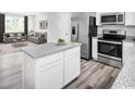 Modern kitchen with stainless appliances, gray countertops, white cabinets and an island with seating at 1008 Oak Meadow Dr., Conway, SC 29526