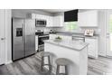 Bright kitchen features stainless steel appliances, granite countertops, white cabinetry, and a central island at 1008 Oak Meadow Dr., Conway, SC 29526