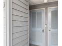 Light blue front door with horizontal slats and gray wood paneled wall at 123 N Dogwood St. # 107, Garden City Beach, SC 29576