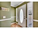 Inviting entryway with a decorative front door flanked by sidelights and green walls with white trim at 1278 Pinetucky Dr., Galivants Ferry, SC 29544