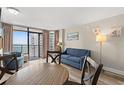 Cozy living room with ocean views from the balcony, comfortable seating, and wood-look floors at 1501 S Ocean Blvd. S # 1147, Myrtle Beach, SC 29577