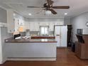 The kitchen features white and wood cabinets, matching countertops, and ample storage space at 1861 Jenerette Rd, Mullins, SC 29574