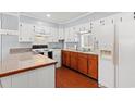 A traditional kitchen with white and wooden cabinets, and a peninsula counter for seating at 1861 Jenerette Rd, Mullins, SC 29574