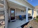 Cozy front porch with comfortable seating, stone accents, and a welcoming entrance at 204 Juniata Loop, Little River, SC 29566
