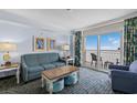 Comfortable living room with stylish furniture and a sliding glass door to a balcony with ocean views at 2201 S Ocean Blvd. # 1707, Myrtle Beach, SC 29577
