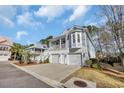 Charming two-story home featuring a double garage, elevated porch, and coastal-inspired architecture at 28 Big Oak Pl., Pawleys Island, SC 29585