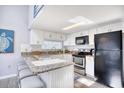 Updated kitchen with granite countertops, modern appliances, and breakfast bar seating at 311 Cumberland Terrace Dr. # 7-F, Myrtle Beach, SC 29572