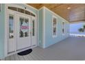 Inviting front porch with beautiful wood ceiling, white trim, and a decorative Easter wreath on the door at 417 Seabreeze Dr., Garden City Beach, SC 29576