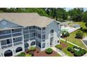 Aerial view of the condo with a pool and trees surrounding the grounds at 4430 Eastport Blvd. # L9, Little River, SC 29566