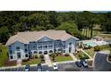 Aerial view showcasing the condo building, parking area, pool, and surrounding greenery at 4430 Eastport Blvd. # L9, Little River, SC 29566