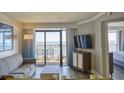 Cozy living room with modern furnishings, slider door, and ocean views with beach-themed decor at 7200 Ocean Blvd. N # 1059, Myrtle Beach, SC 29572