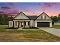 Charming single-Gathering home featuring black trim, a covered front porch, and an attached two-car garage at sunset at 1052 Merritt Rd, Conway, SC 29526