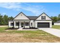 Charming single-Gathering home featuring black trim, a covered front porch, and an attached two-car garage at 1052 Merritt Rd, Conway, SC 29526