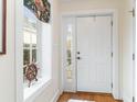 Bright foyer with a white door, a charming window with a ship's wheel, and gleaming hardwood floors at 1523 James Island Ave., North Myrtle Beach, SC 29582