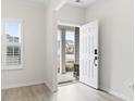 Inviting entryway with a view to the home's exterior, and light hardwood flooring at 179 Crabapple Dr., Longs, SC 29568