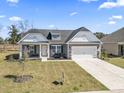 Lovely single-Gathering home boasts a two-car garage, manicured lawn, and inviting curb appeal at 179 Crabapple Dr., Longs, SC 29568