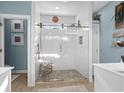 Bright bathroom featuring a modern glass-enclosed shower with decorative mosaic floor tiles and a bench at 221 Shenandoah Dr., Murrells Inlet, SC 29576