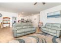 Open concept living room with hardwood floors, leather sofas, and view to the kitchen at 255 Marauder Dr., Longs, SC 29568