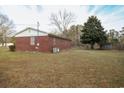 Brick home with a well-kept lawn and an outbuilding in the backyard at 3285 Della Rd., Longs, SC 29568