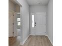 Inviting entryway with light wood flooring and a bright white front door with sidelight window at 495 Wagner Cir., Conway, SC 29526