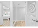 Bright hallway leading to a bedroom, featuring light wood floors, white trim, and fresh gray paint at 601 Mitchell Dr. # 203, Myrtle Beach, SC 29577